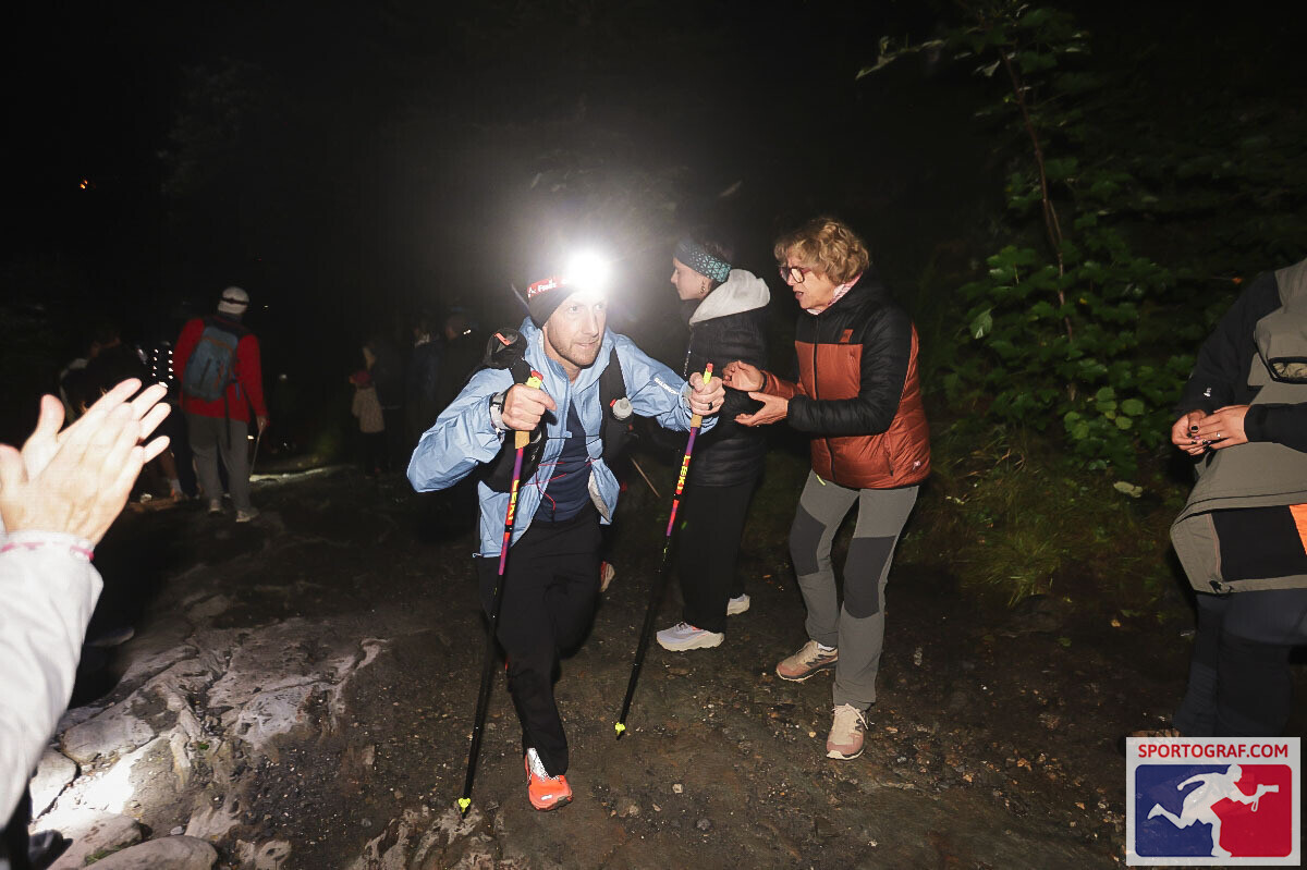 Runner climbing a night trail section with a headtorch